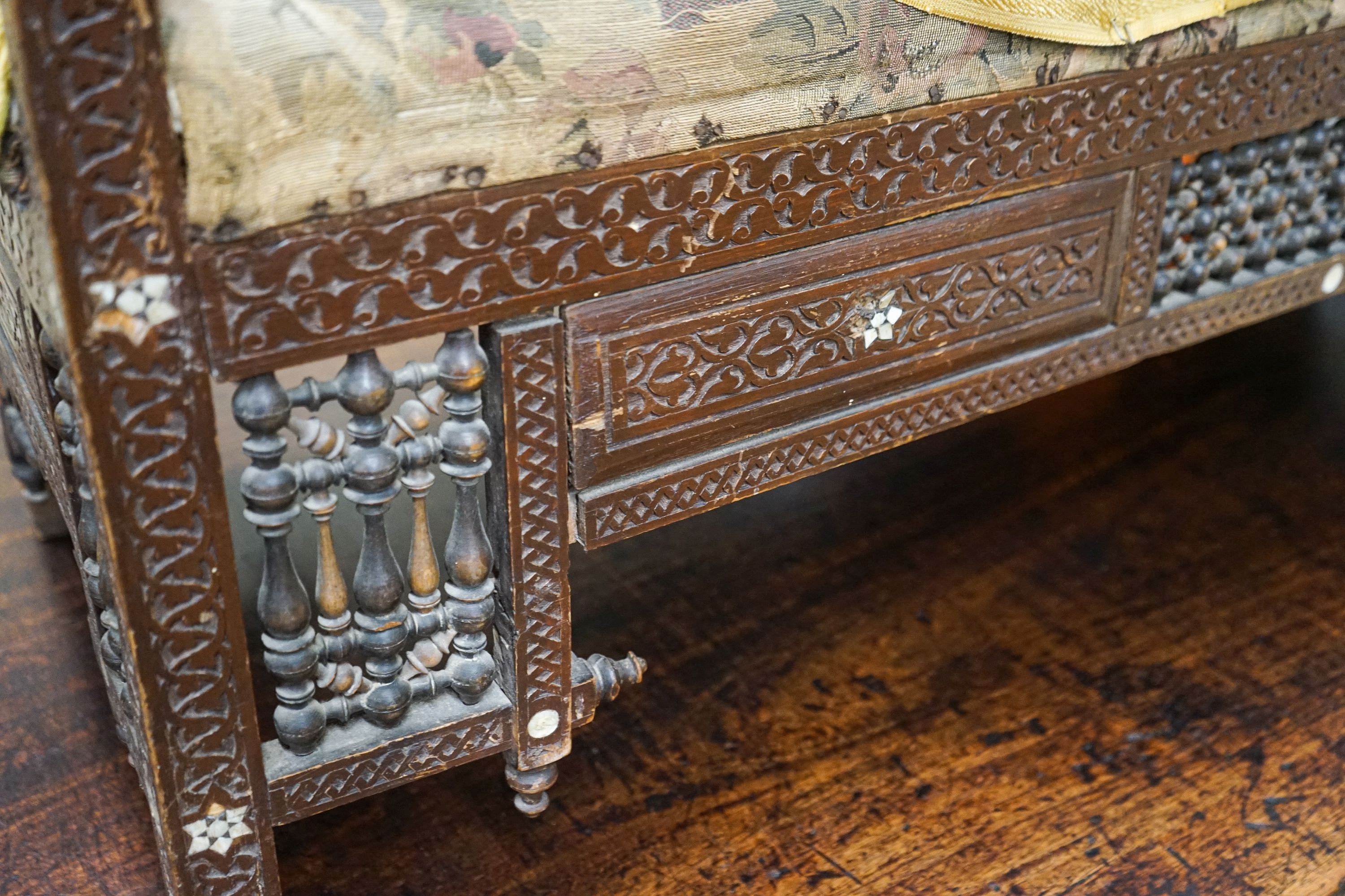 An early 20th century Moorish mother of pearl inlaid carved hardwood window seat, length 134cm, depth 44cm, height 64cm